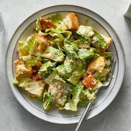 Draufsicht auf Miso-Caesar-Salat in einer Schüssel mit Metallgabel im Essen